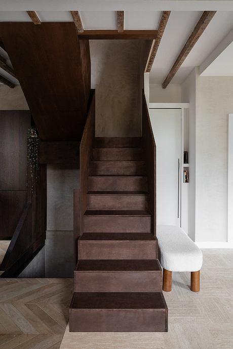 Rustic wooden stairs with concrete steps leading to a modern, minimalist living space.
