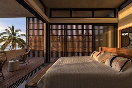 Spacious bedroom with expansive windows, wood paneling, and palm tree view.