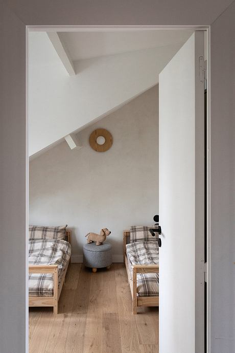 Minimalist bedroom with wooden beds, plaid bedding, and a circular decor accent.