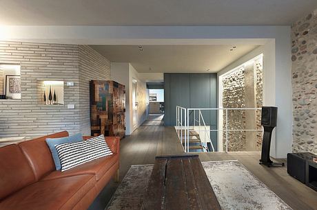 Open-concept living space with exposed brick, wooden furniture, and architectural details.