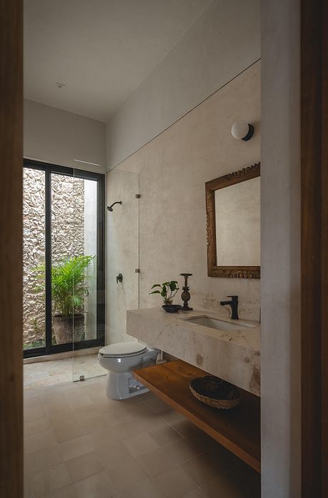 Elegant bathroom with stone walls, marble vanity, and wooden shelf. Minimalist design.