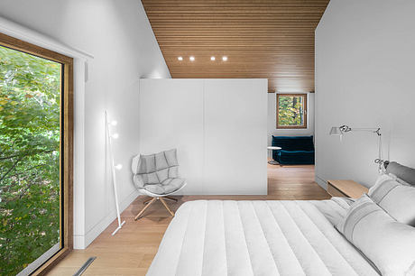 Minimalist bedroom with wooden ceiling, large window, and modern furnishings.