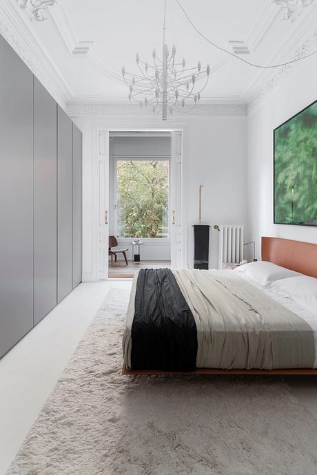 Ornate ceiling, modern furniture, and expansive window with lush outdoor view.