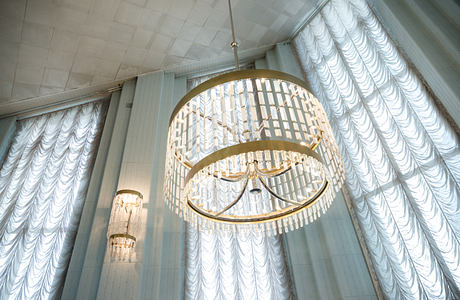 Ornate crystal chandeliers illuminate the elaborate curtained interior space.