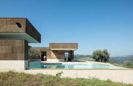 A modernist building with geometric shapes, a swimming pool, and sweeping views of the landscape.