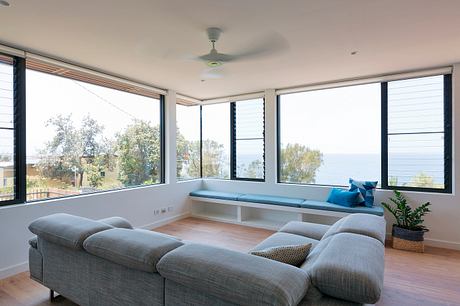Spacious and airy living room with large windows offering panoramic views of the outdoors.