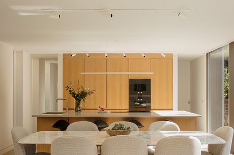 Spacious, modern kitchen with sleek wooden cabinetry, ample countertop, and track lighting.