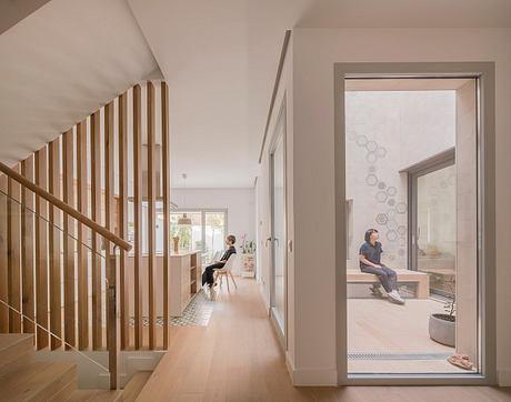 Bright, open-concept home with wooden staircase, polished floors, and large windows.