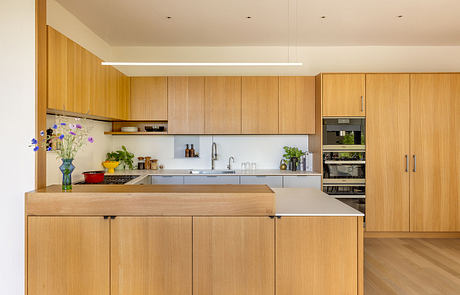 A modern kitchen with wooden cabinets, a sleek sink, and colorful accents.