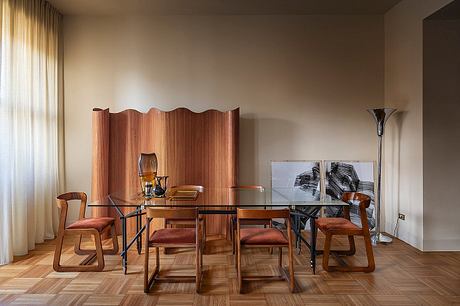 Elegant dining room featuring wooden furniture, glass table, and textured wall paneling.