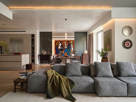 A stylish modern living room with a vibrant abstract art piece, sleek furniture, and warm lighting.