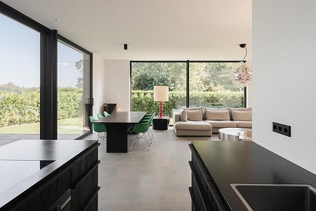 Spacious, modern living room with sleek furniture, large windows, and a dining area.