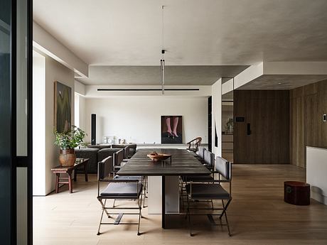 Spacious dining room with minimalist decor, wooden furniture, and industrial pendant light.