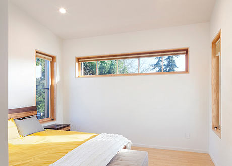 Bright, airy room with large windows, wooden accents, and a cozy, minimalist decor.
