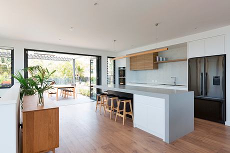 Spacious modern kitchen with wood accents, large windows, and an open floor plan.