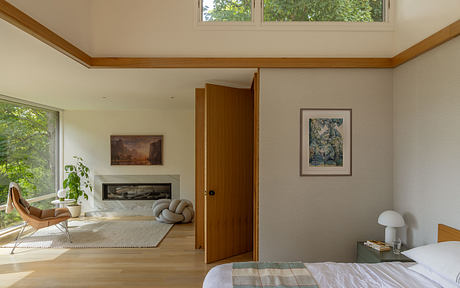 Bright, open-concept bedroom with wood accents, artwork, and natural light.