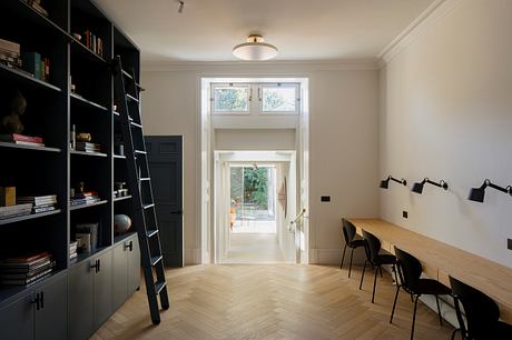 A modern, minimalist room with built-in shelving, hardwood floors, and simple furnishings.