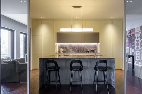 Sleek, modern kitchen with a striking black island, pendant lighting, and patterned accent wall.