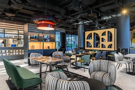 Vibrant modern restaurant interior with geometric patterns, lighting fixtures, and cozy seating.