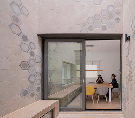 Hexagon-patterned tiles and expansive glass walls highlight the modern interior design.