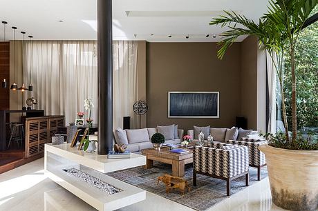 Elegant open-plan living space with modern furniture, lush greenery, and natural lighting.