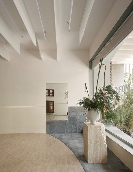 Elegant minimalist interior with clean lines, stone tiles, and a potted plant.