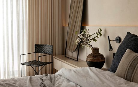 Cozy bedroom with neutral textiles, decorative lighting, and woven furniture accents.