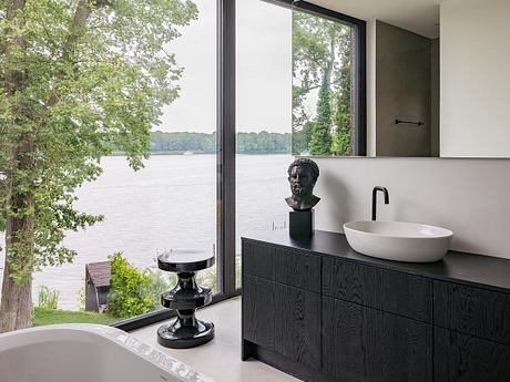 Sleek modern bathroom with expansive views of the lake through floor-to-ceiling windows.