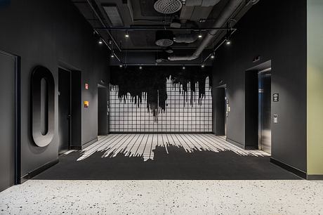 A dark, moody interior with graphic patterns on the walls, floors, and ceiling, creating an immersive environment.