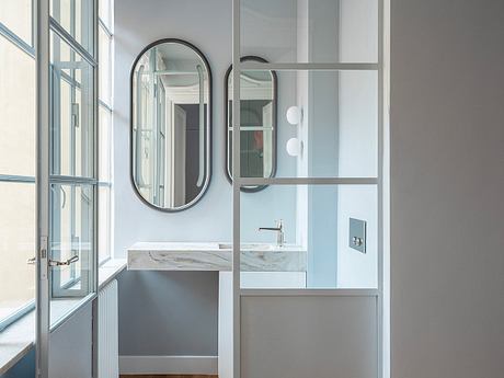 Minimalist bathroom design with sleek mirror, vanity, and glass partition.