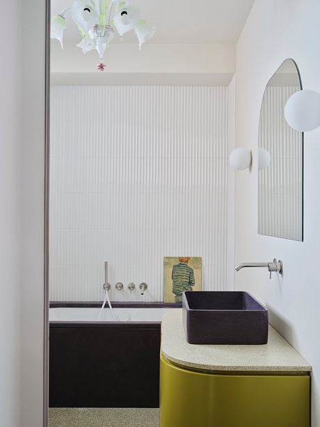 Contemporary bathroom with minimalist vanity, black vessel sink, and abstract artwork.
