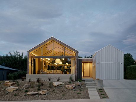 Modern, open-concept home with glass walls, warm lighting, and natural materials.