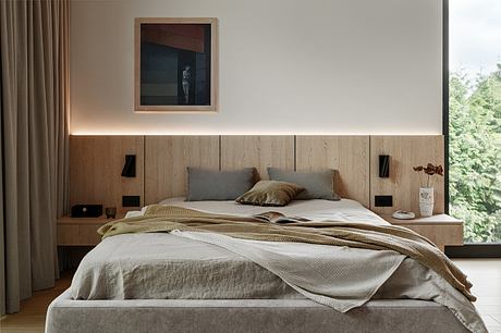 Cozy, minimalist bedroom with warm wood accents, built-in storage, and framed artwork.