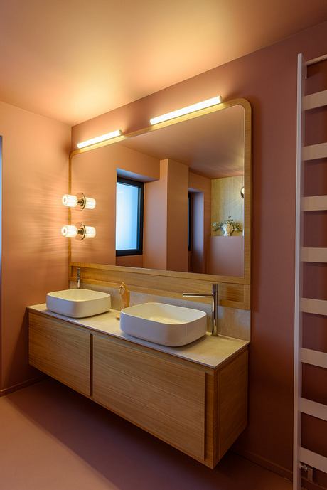 Well-designed modern bathroom with wooden vanity, vessel sinks, and lighted mirror.