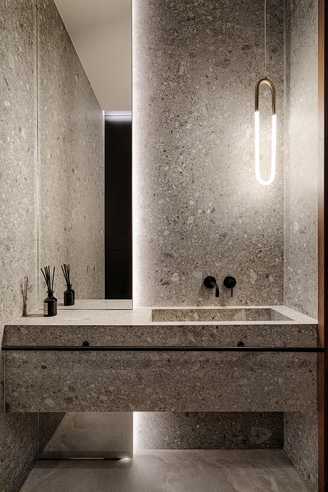 Minimalist bathroom with sleek grey marble walls, suspended vanity, and modern lighting.