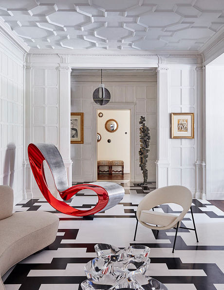 Ornate ceilings, modern sculptural furniture, and bold black-and-white floor tiles.