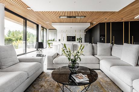 Minimalist yet sophisticated living room with modern wooden ceiling, sleek furniture, and large windows.
