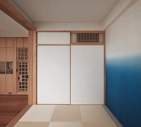 Elegant minimalist Japanese-inspired interior with wooden panels, tatami mats, and blue accent wall.