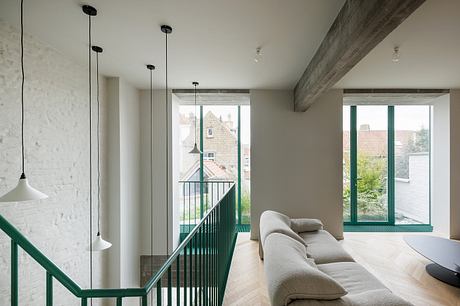 Spacious, modern interior with exposed beams, pendent lights, and large windows overlooking outdoors.