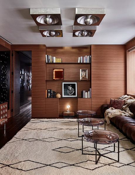 Cozy living room with sleek wood paneling, recessed lighting, and stylish furniture.
