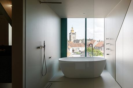 Elegant contemporary bathroom design with a freestanding tub and panoramic city view.