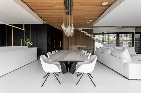 Sleek, modern dining area with a dramatic glass chandelier and black-and-white decor.