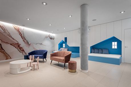 Contemporary lobby with striking marble walls, sculptural furniture, and vibrant blue accents.