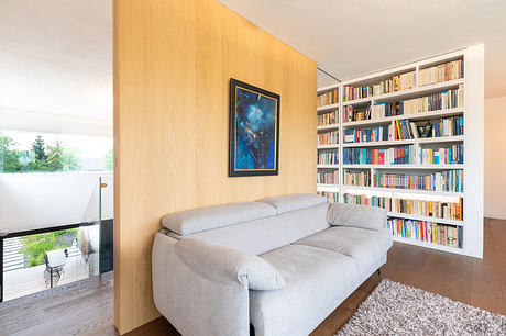 Cozy living room with built-in wooden bookshelves, plush gray sofa, and nature-themed artwork.