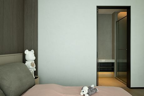 Minimalist bedroom with dark wood paneling, plush bedding, and modern built-in shelving.