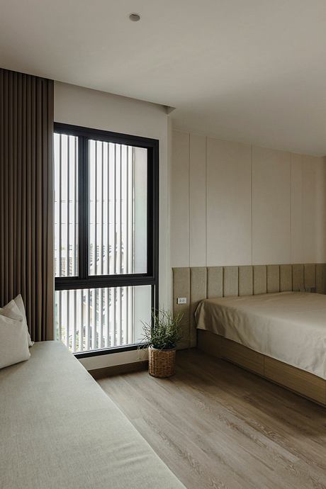 Minimalist bedroom with large window, built-in headboard, and muted color palette.
