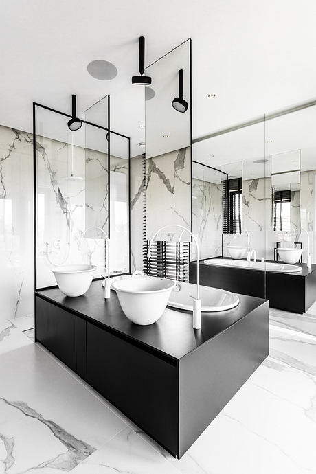 Sleek, minimalist bathroom design with black vanity, marble walls, and geometric lighting.