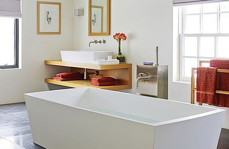 A contemporary bathroom with a freestanding white bathtub, wooden vanity, and stylish accents.