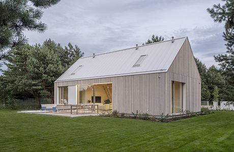 Kownatki Lake House Calm Geometry: Metal-Clad Refuge in the Pines