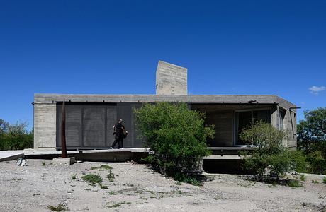 Casa Cosmos: Rammed Stone and Exposed Concrete on a Sloped Site Edge